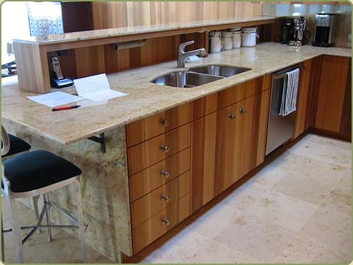 kitchen cabites in this image match the wall red cedar paneling