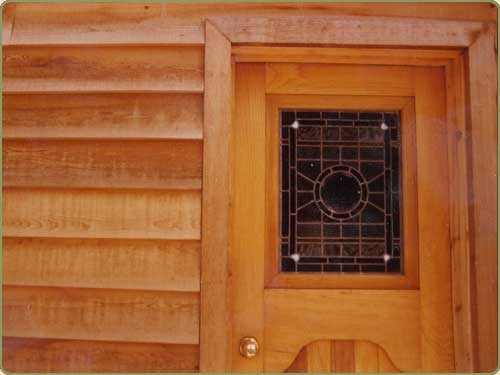 Image of a door with western red cedar trim, also shown is bevel siding